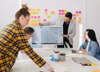 man standing behind flat screen computer monitor