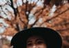 smiling woman wearing black hat and brown scarf