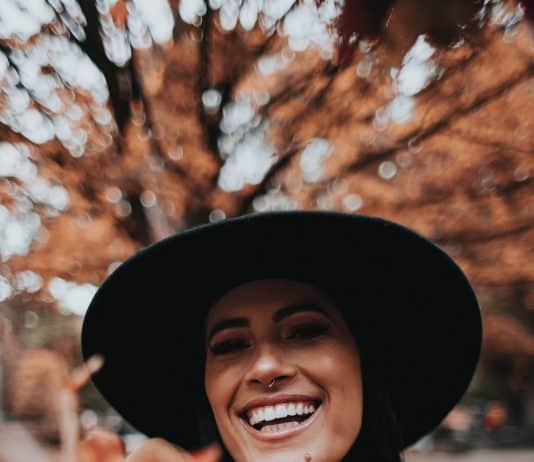 smiling woman wearing black hat and brown scarf