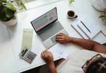a person sitting at a table with a laptop