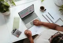 a person sitting at a table with a laptop