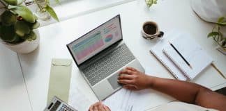 a person sitting at a table with a laptop